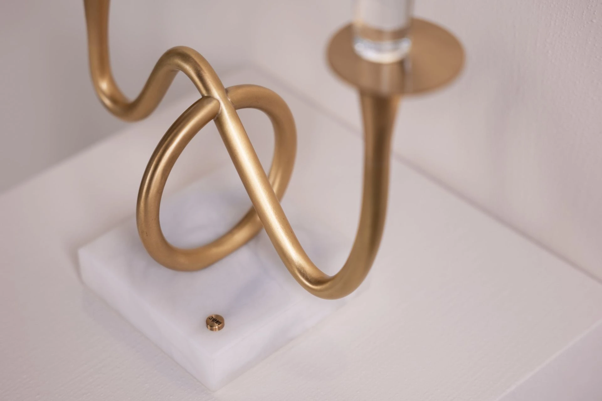 Two-light edition — detail of the curved brass arm