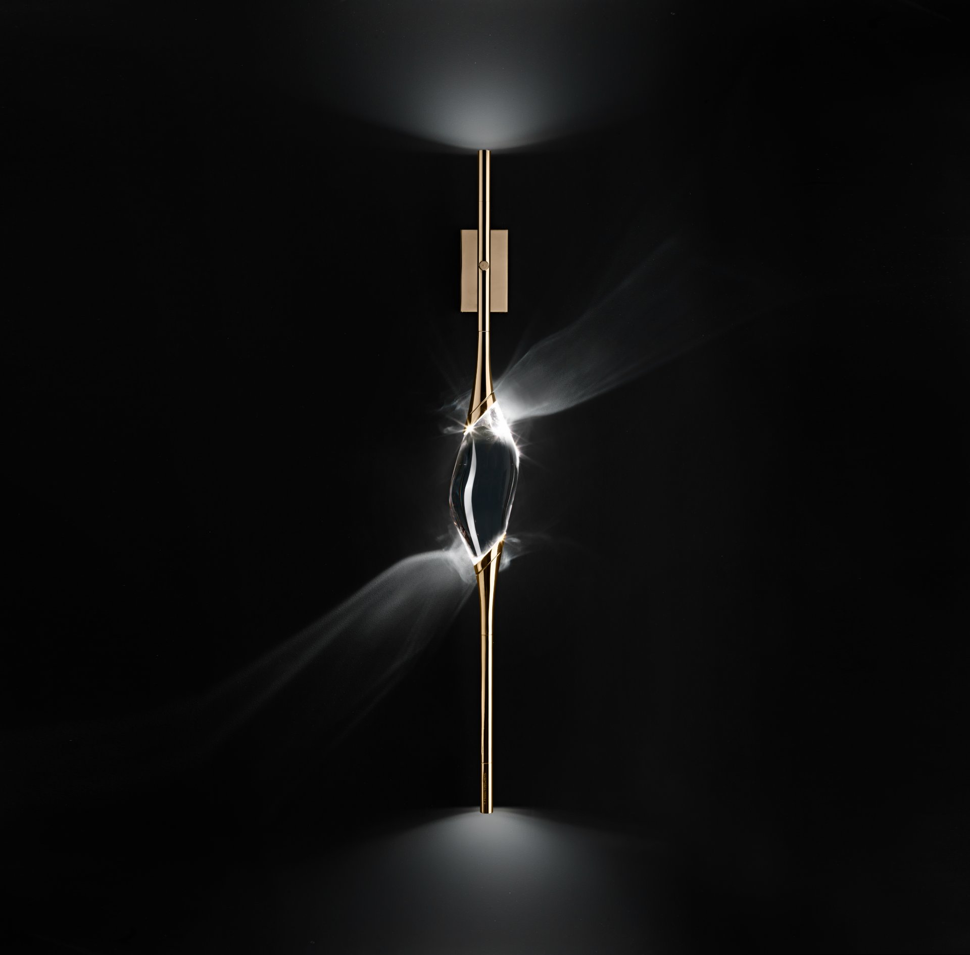 Il Pezzo 12 Wall Sconce in gold finish, lit on a dark ground