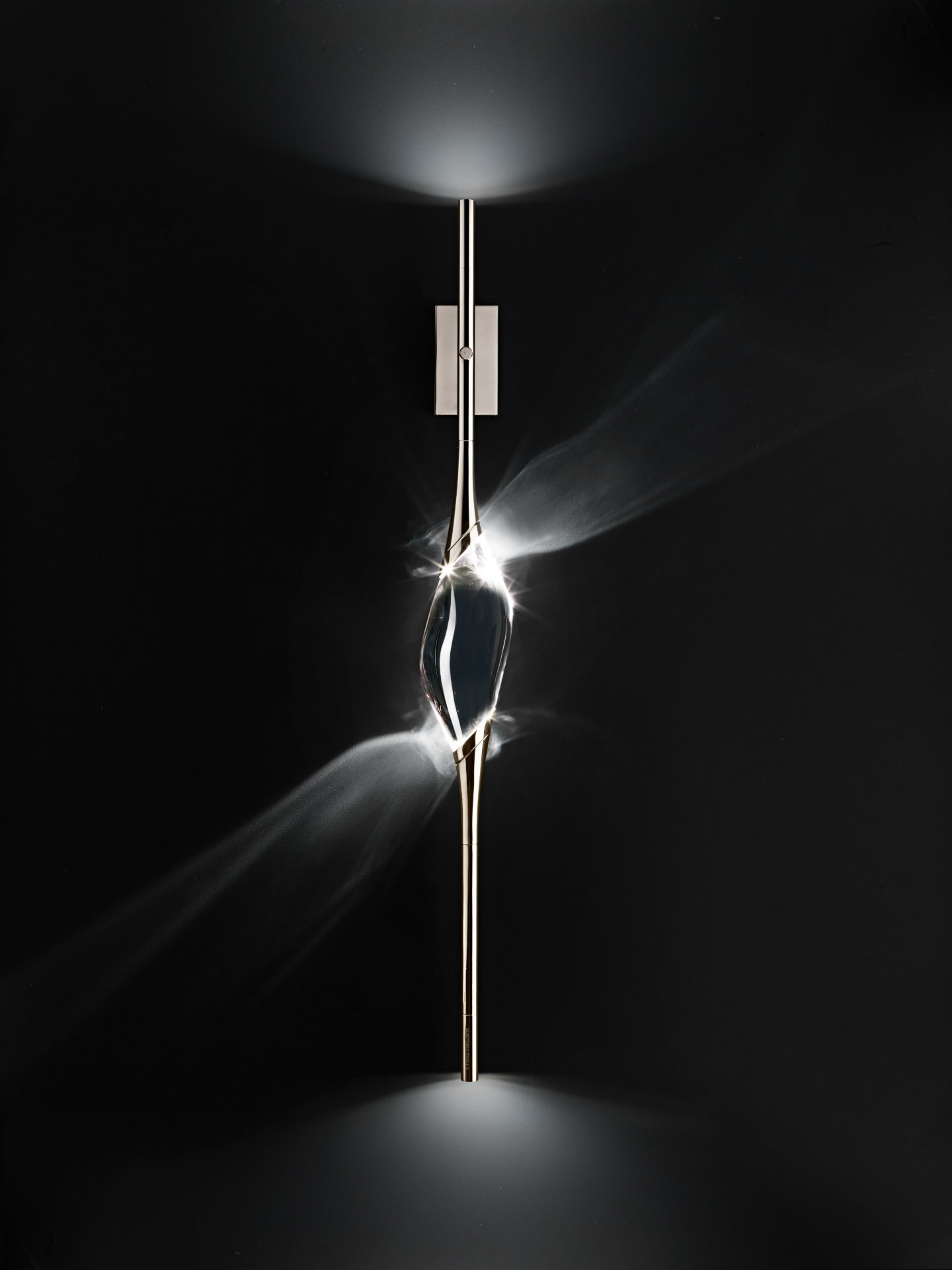 The solid crystal of Il Pezzo 12 Wall Sconce lit at the centre of the stem, nickel finish
