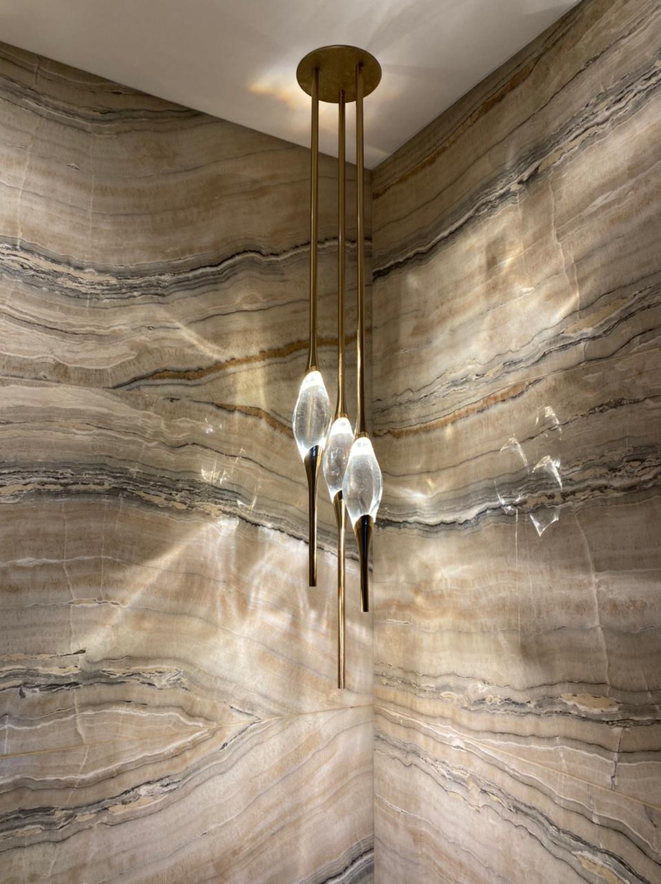 Il Pezzo 12 Round Chandelier in gold against onyx walls, private residence in Santa Cruz, Bolivia
